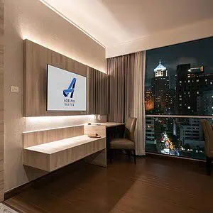 A one-bedroom suite at Adelphi Suites Bangkok with a separate bedroom, living area and night view over Sukhumvit