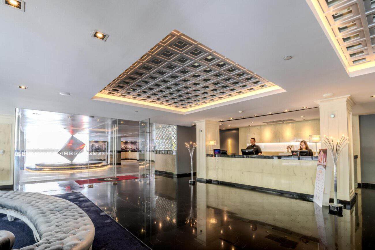 A staffed hotel reception desk in Bangkok with the lobby entrance in view