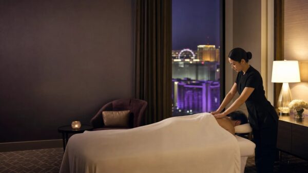 Masseuse giving an outcall massage in a Bangkok hotel room with a city view