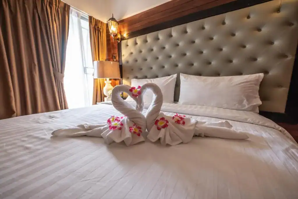 A Thai short-stay hotel room made up with towel swans, illustrating the standard fit-out of the category