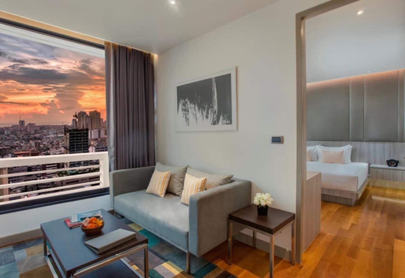 The living room of a Fraser Suites Sukhumvit penthouse on Soi 11, with a full sofa, coffee table and the bedroom through the opening
