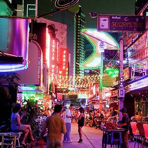 Soi Cowboy at night between Sukhumvit Soi 21 and 23, neon bar signs along the strip