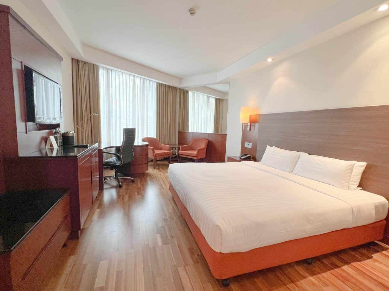 A renovated room at the Rembrandt Hotel Bangkok on Sukhumvit Soi 18, with wood floors, desk and a separate seating area