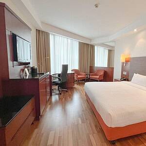 A renovated room at the Rembrandt Hotel Bangkok on Sukhumvit Soi 18, with wood floors, desk and a separate seating area