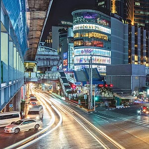 The Asok junction on Sukhumvit at night, Terminal 21 and the BTS above a jam of cars and motorbikes