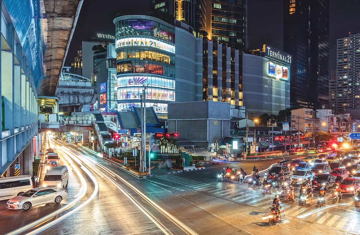 The Asok junction on Sukhumvit at night, Terminal 21 and the BTS above a jam of cars and motorbikes