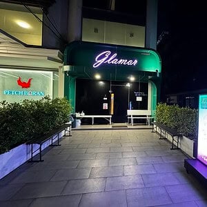 Illuminated Glamor sign and lightbox at the entrance to Glamor Nuru Massage, Sukhumvit Soi 31, Bangkok, at night