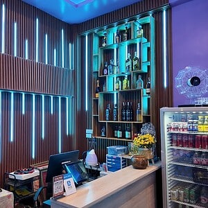 KTV bar at Lumi Nuru Massage & KTV, Sukhumvit 39, Bangkok, with LED-lit wood slats and a spirits shelf