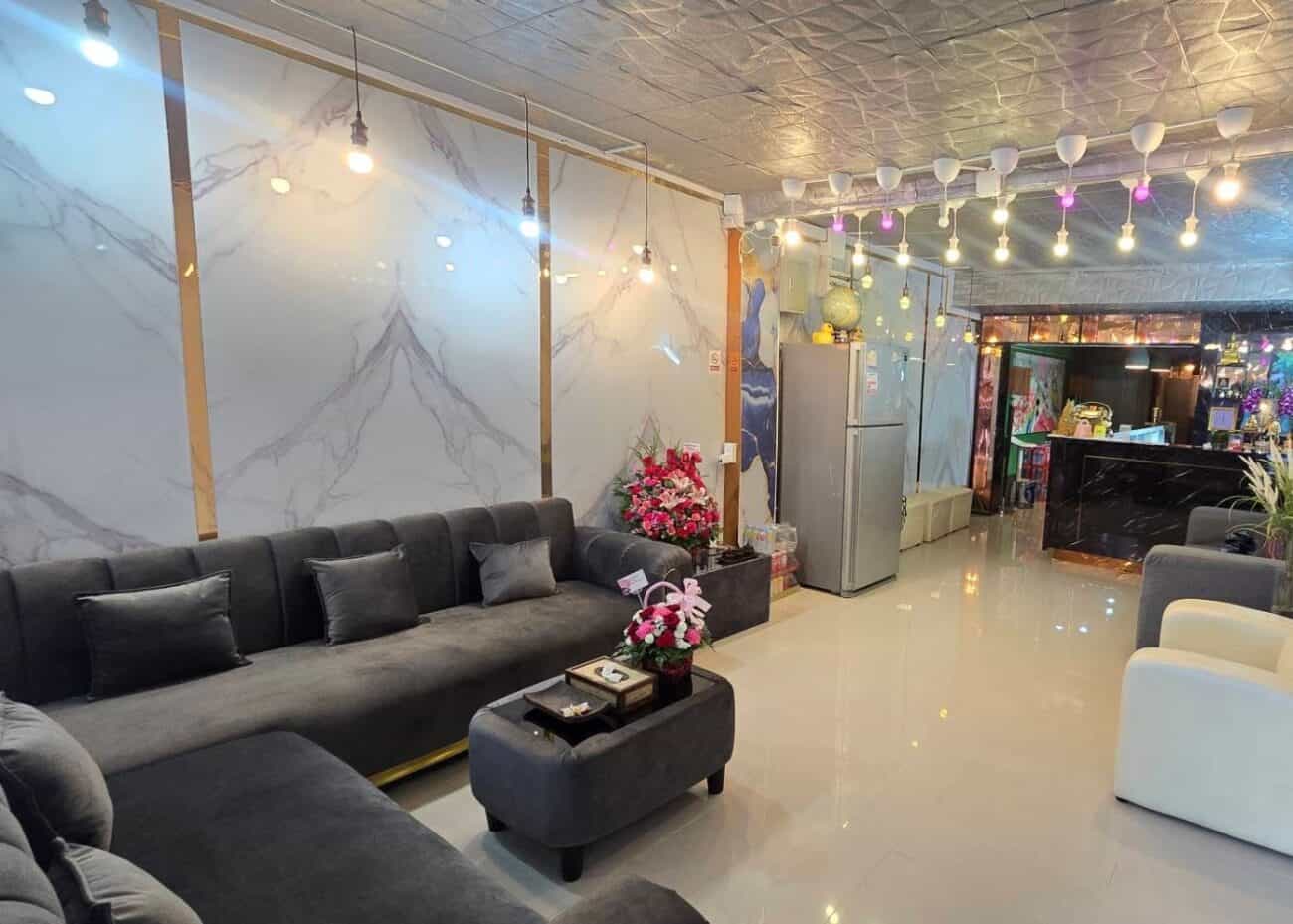 Marble-walled reception lounge with grey sofas at Airy Massage, lower Sukhumvit, Bangkok