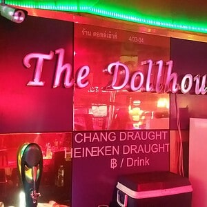 The Dollhouse sign behind the bar at the Soi Cowboy go-go, with its draught beer board