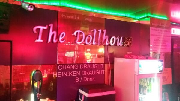 The Dollhouse sign behind the bar at the Soi Cowboy go-go, with its draught beer board
