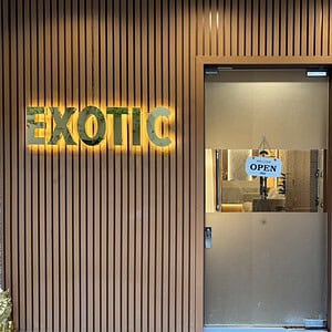 Lit EXOTIC sign beside the glass entrance of Exotic Massage, Bangkok