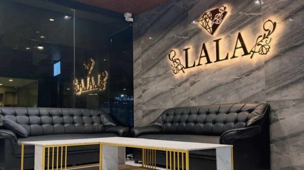 Illuminated LALA sign above the black leather sofas in the lobby of LALA Nuru Massage, Sukhumvit Soi 26