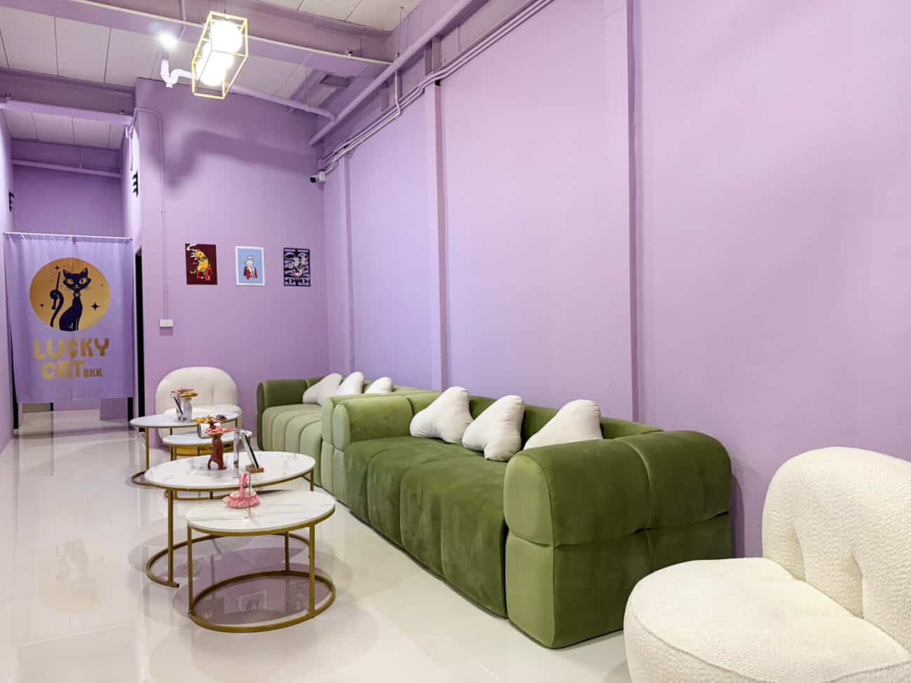 Lilac waiting lounge at Lucky Cat BKK on Sukhumvit Soi 18, Bangkok, with the Lucky Cat logo on the curtain