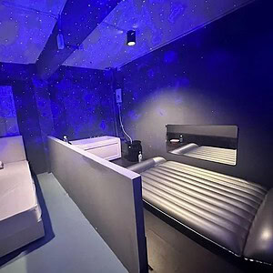 Room at Lunar Nuru Massage, Sukhumvit Soi 30, with a bed, nuru mattress and bathtub under a starry ceiling