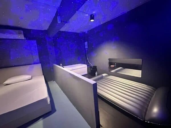 Room at Lunar Nuru Massage, Sukhumvit Soi 30, with a bed, nuru mattress and bathtub under a starry ceiling