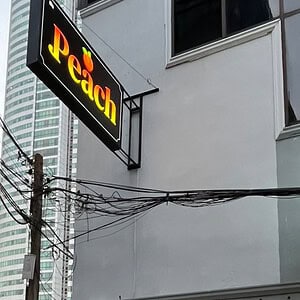 Illuminated Peach sign above the massage shop on Sukhumvit Soi 20, Bangkok